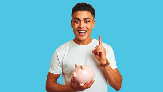 Man holding a piggy bank pointing up